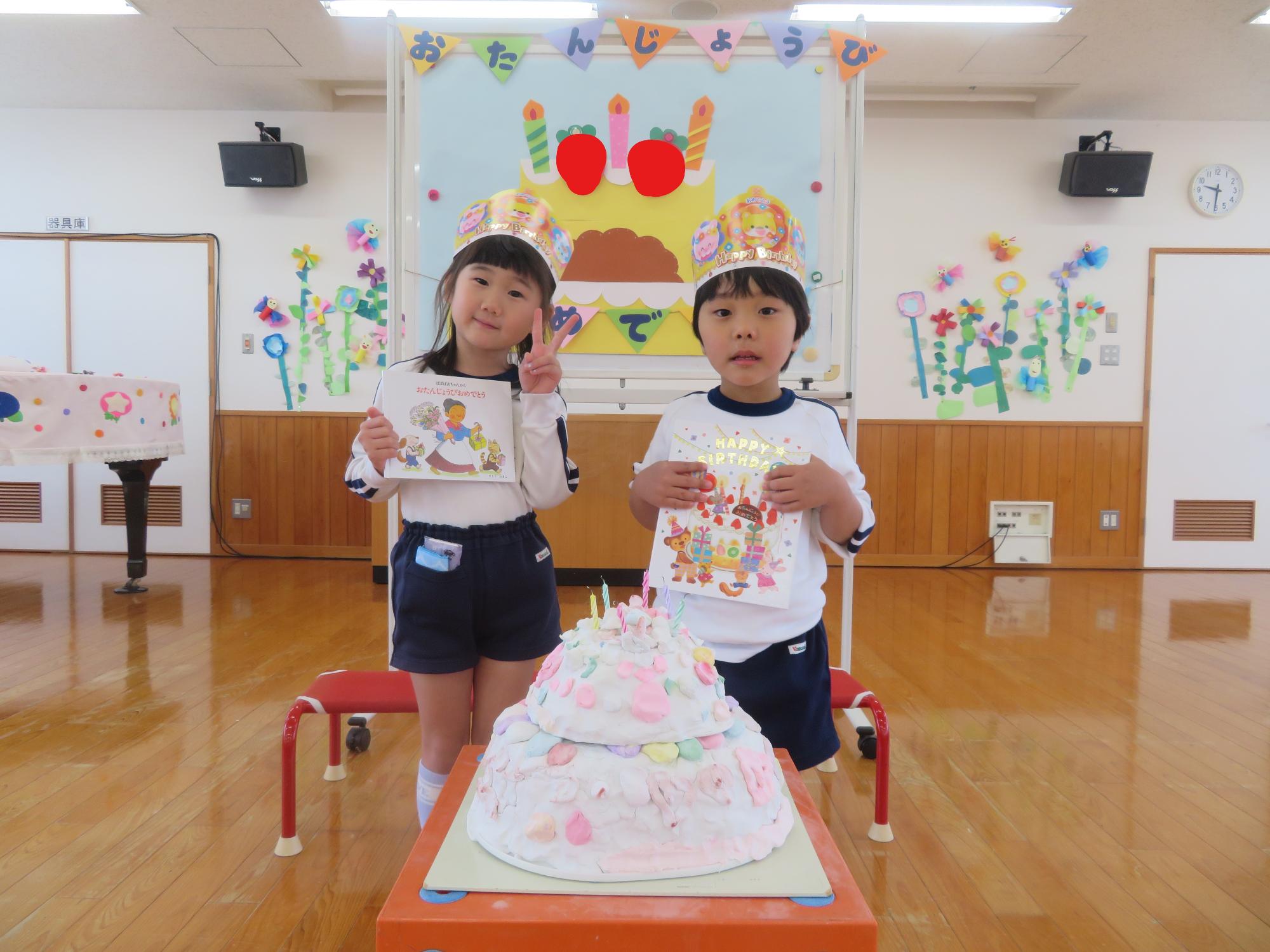 誕生児がケーキと一緒に記念写真を撮っているところ。