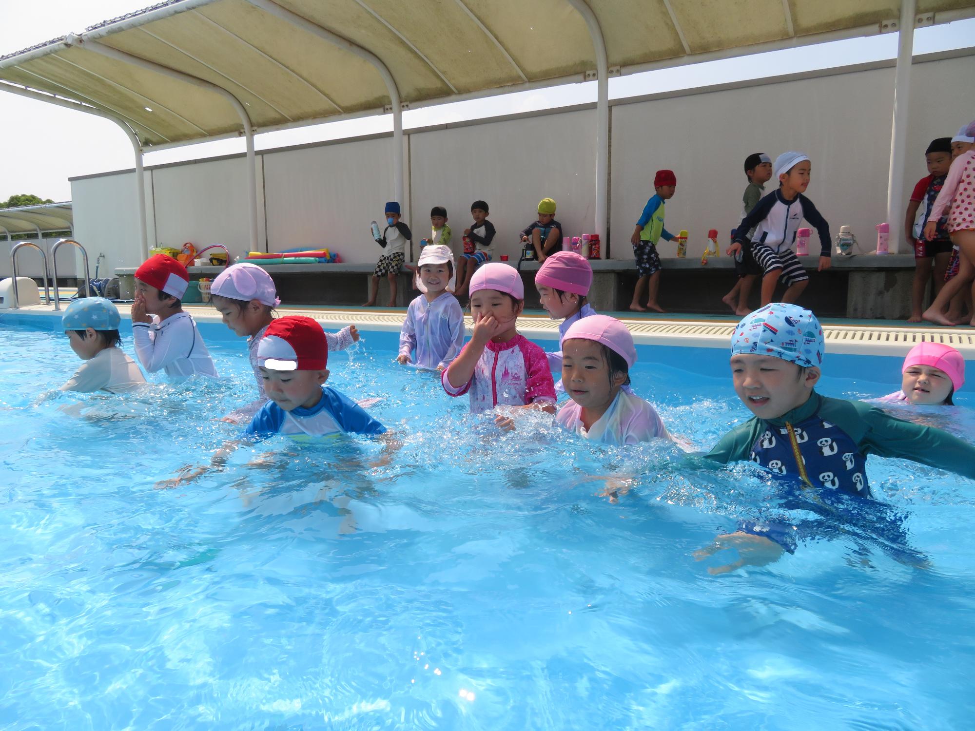 4・5歳児が小学校プールで遊んでいるところ。