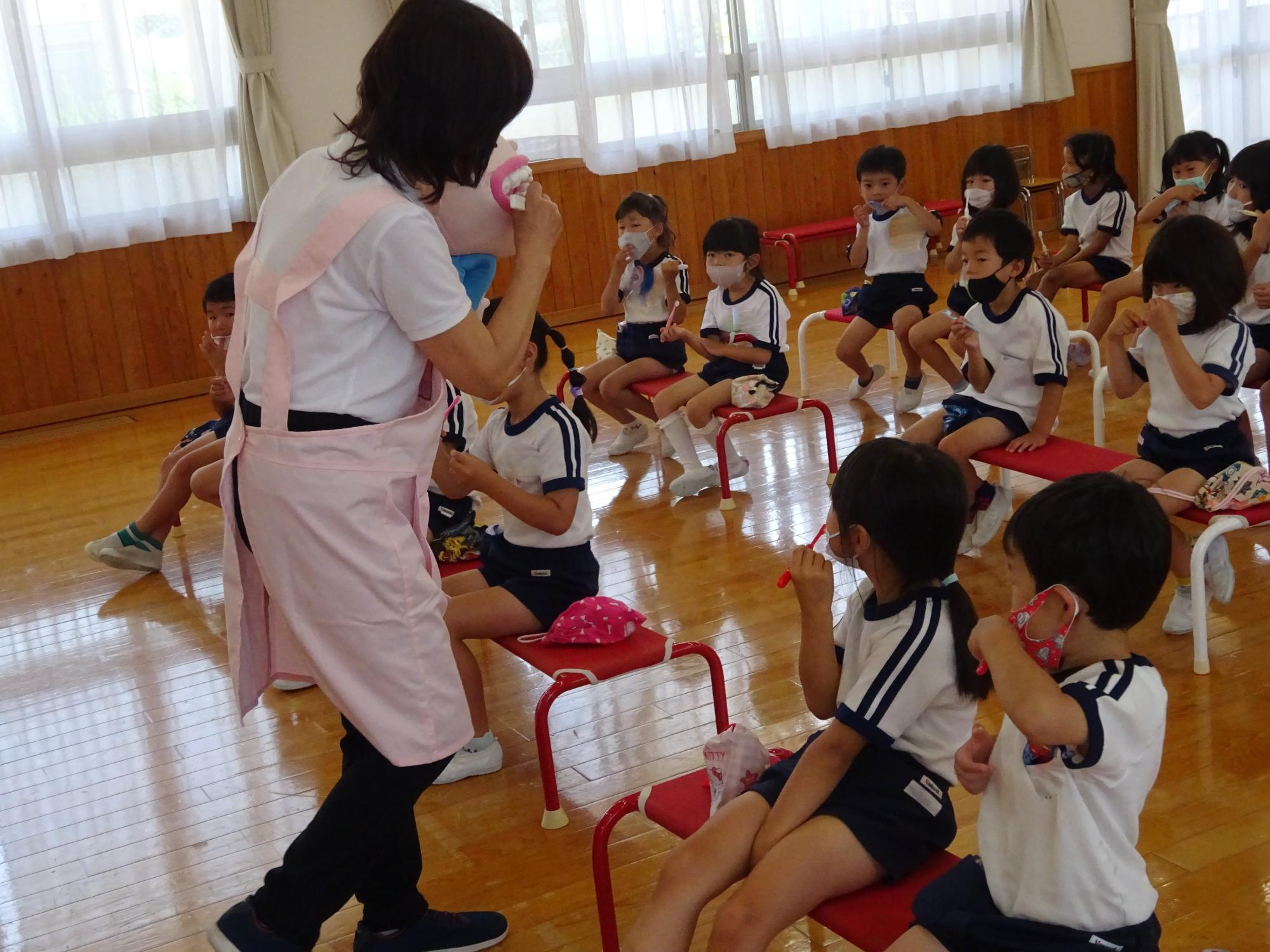 三輪小学校養護教諭が5歳児に歯磨き指導をしているところ