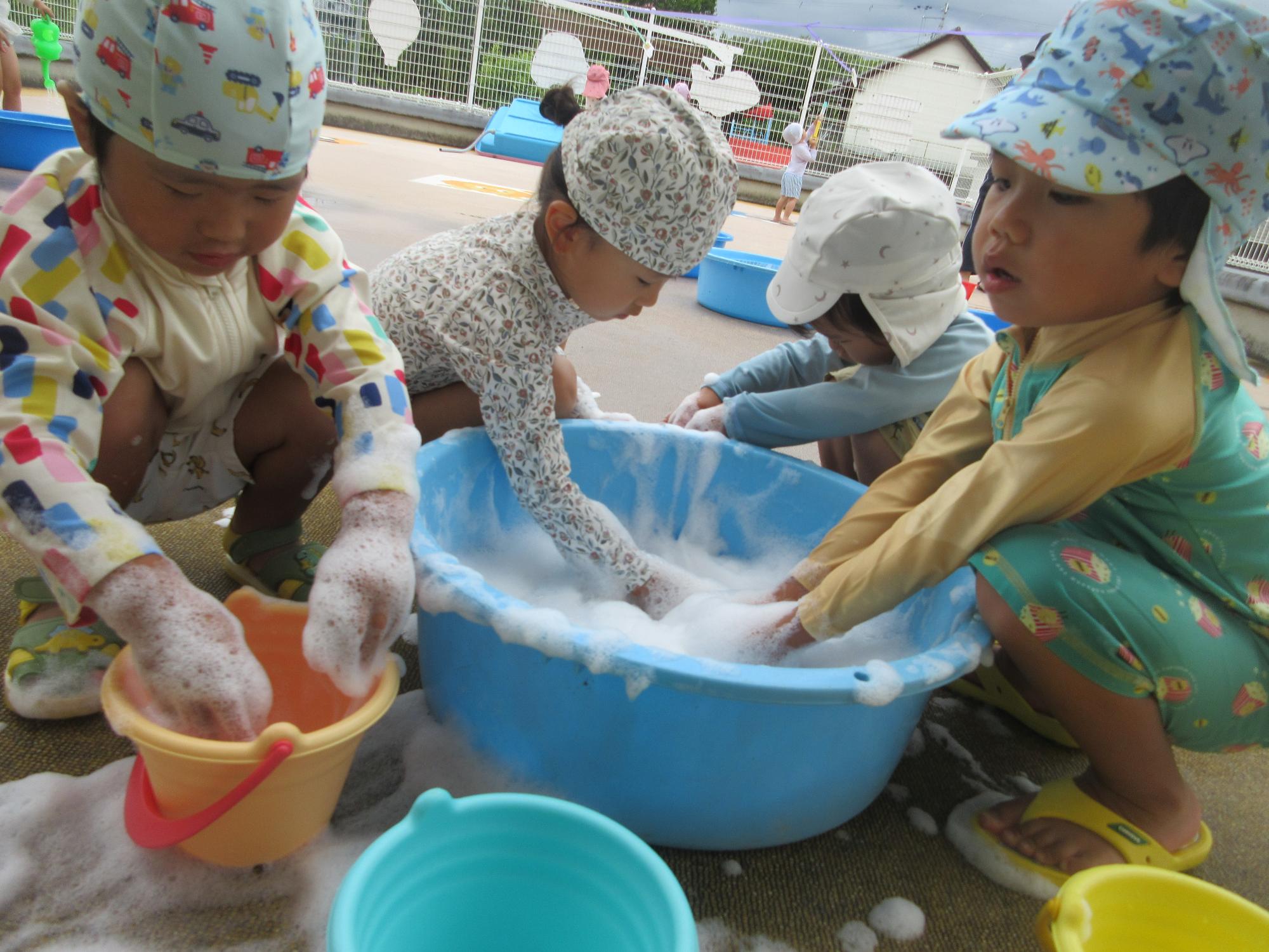 タライで泡遊びをしている子どもたち