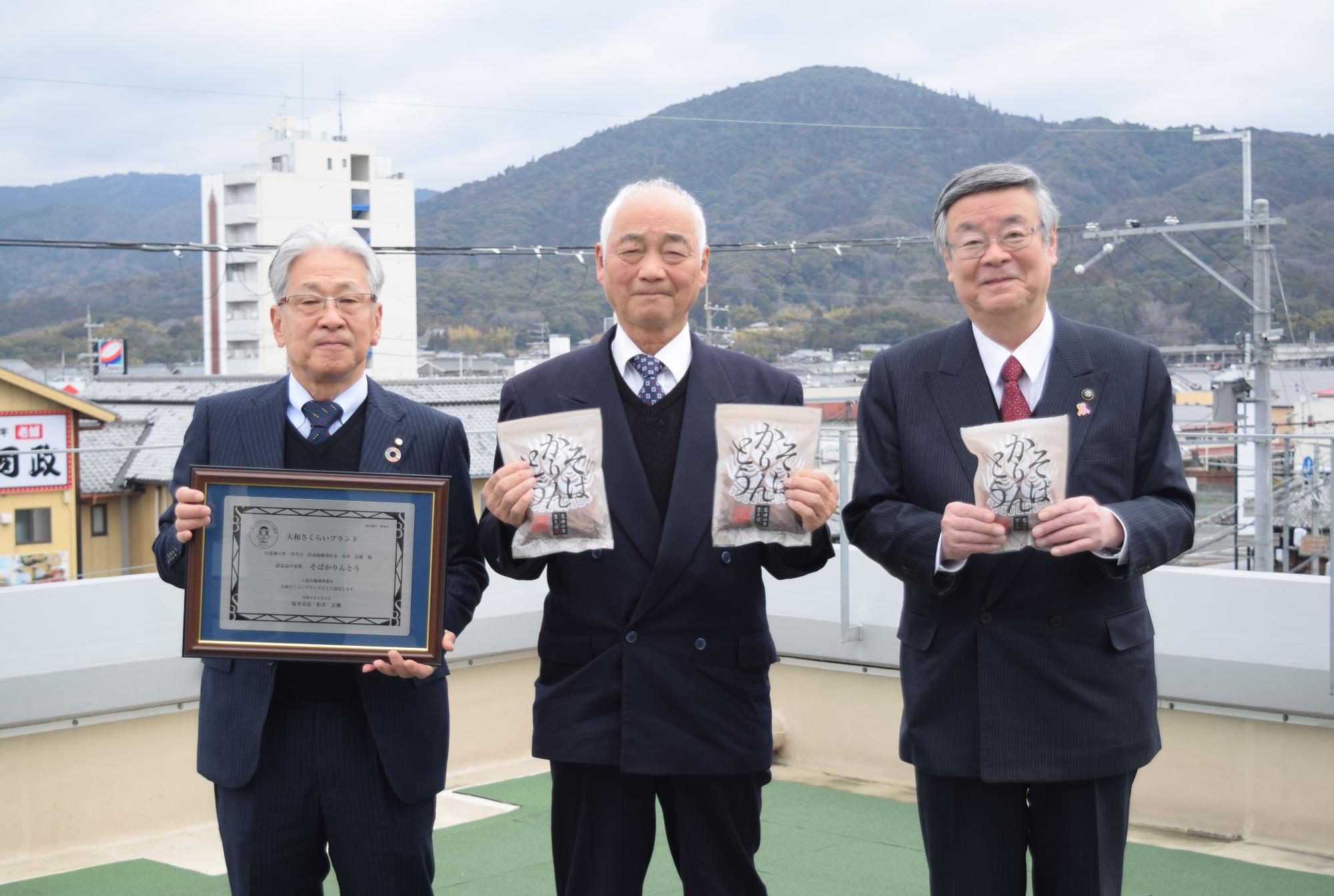 福井委員長・山本社長・松井市長の三輪山を背景にした集合写真